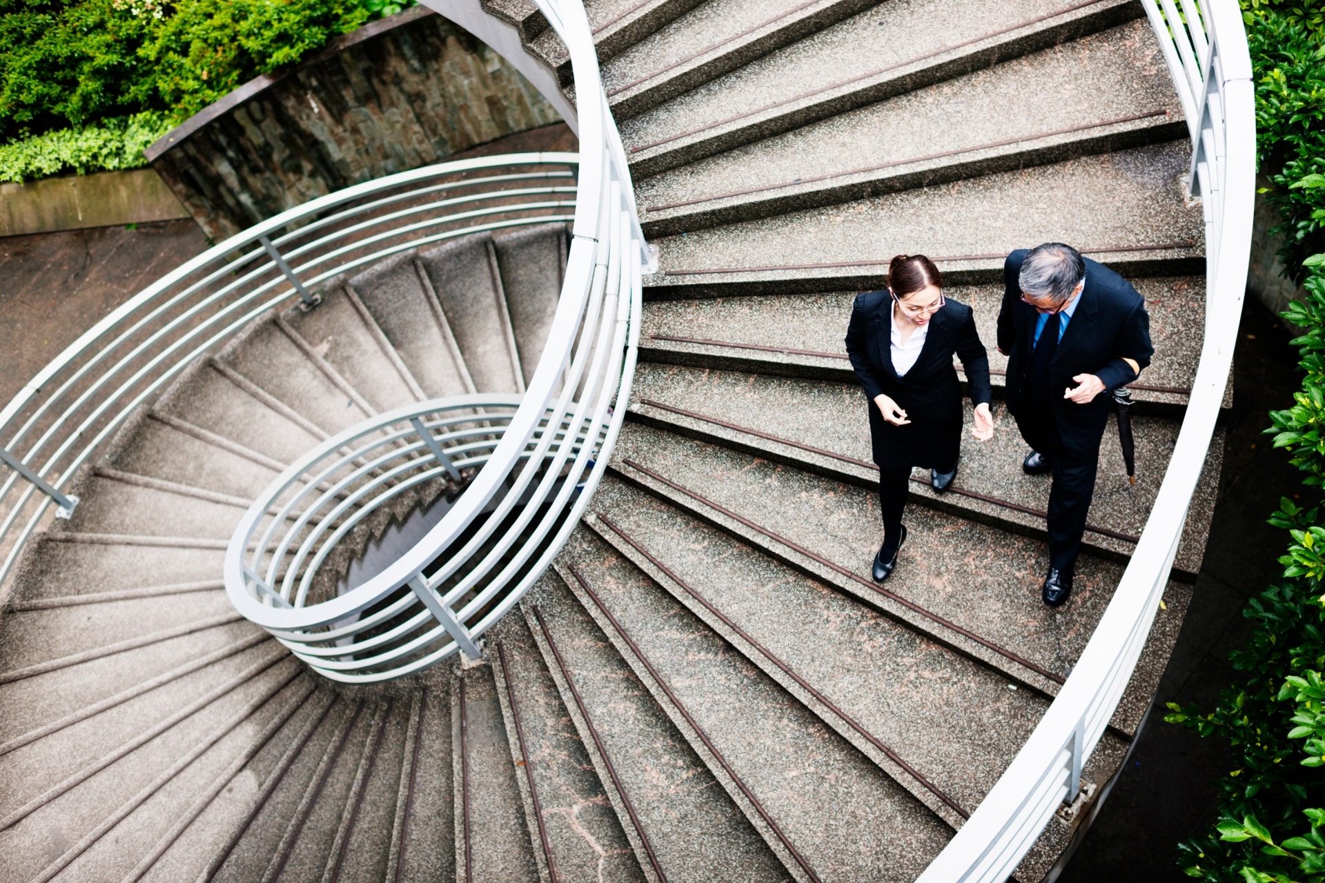 corporate employees walking down spiral staircase